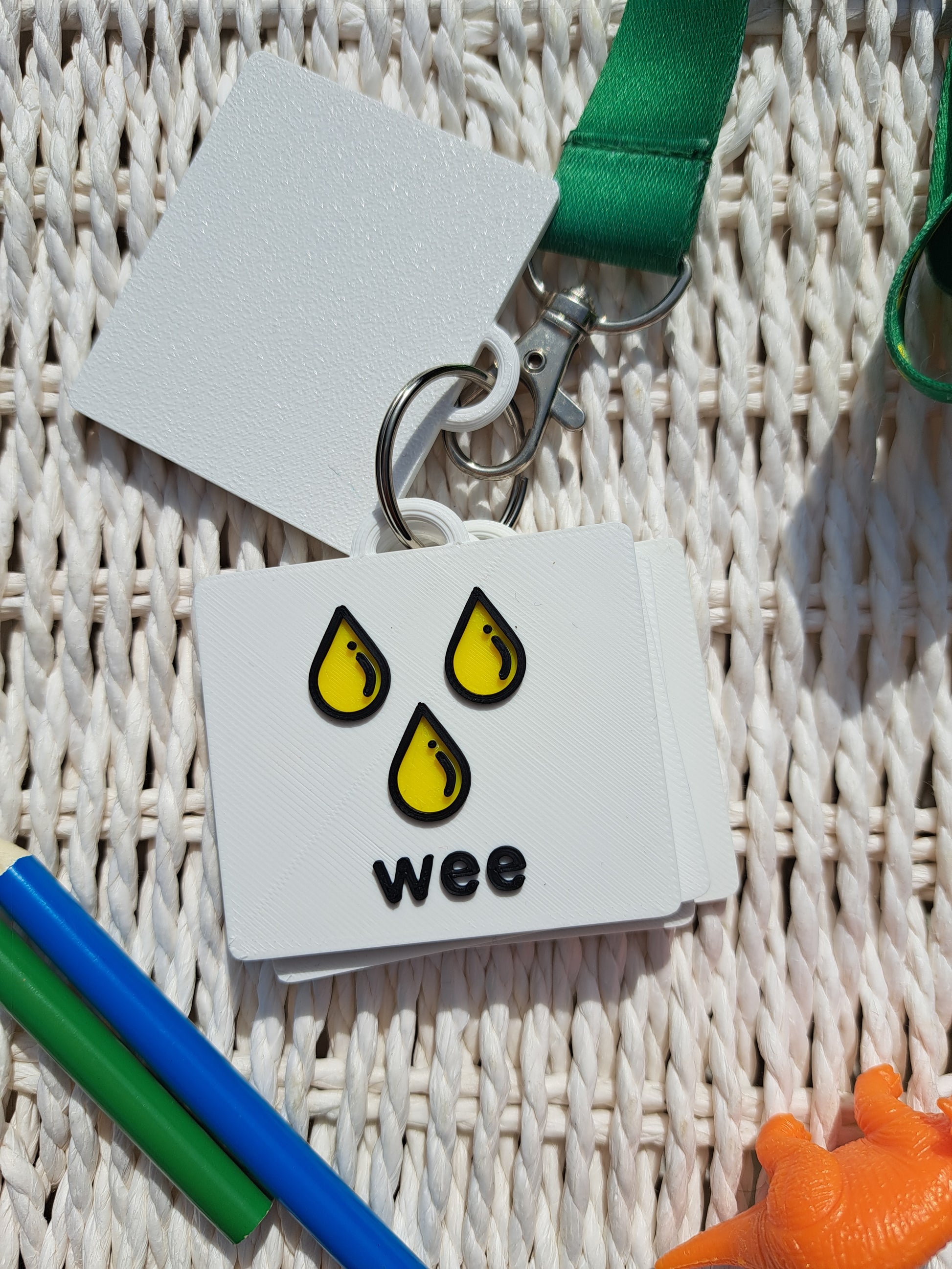 Close-up of the ‘wee’ tag from the toilet communication set, showing raised text and symbol.