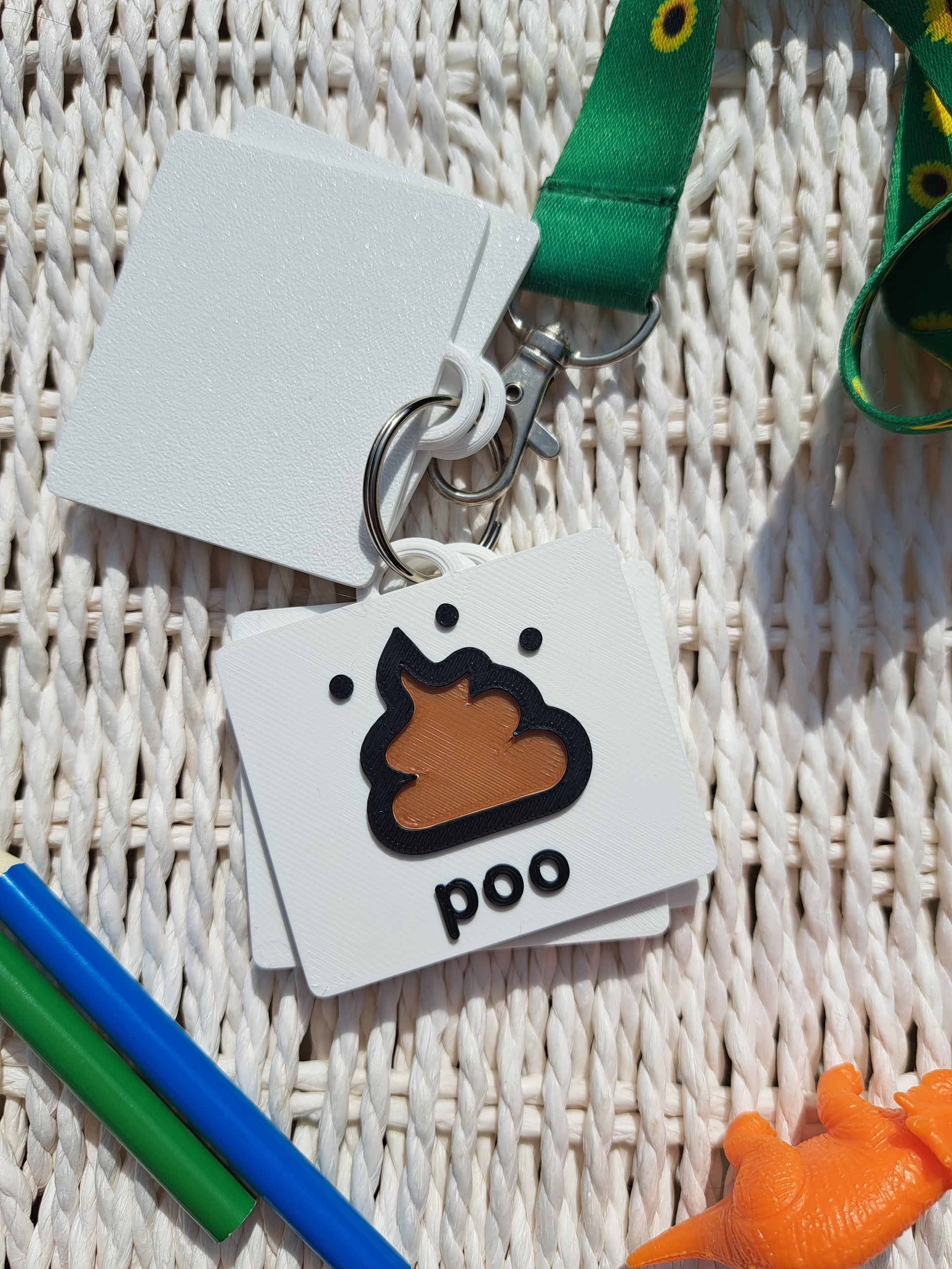 Close-up of the ‘poo’ tag from the toilet communication set, showing raised text and symbol.