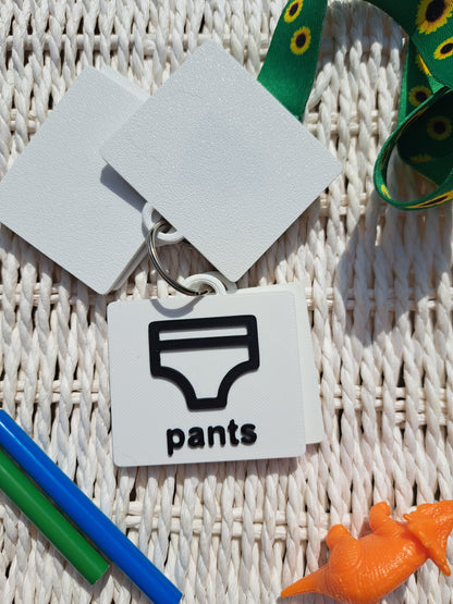 Close-up of the ‘pants’ tag from the toilet communication set, showing raised text and symbol.