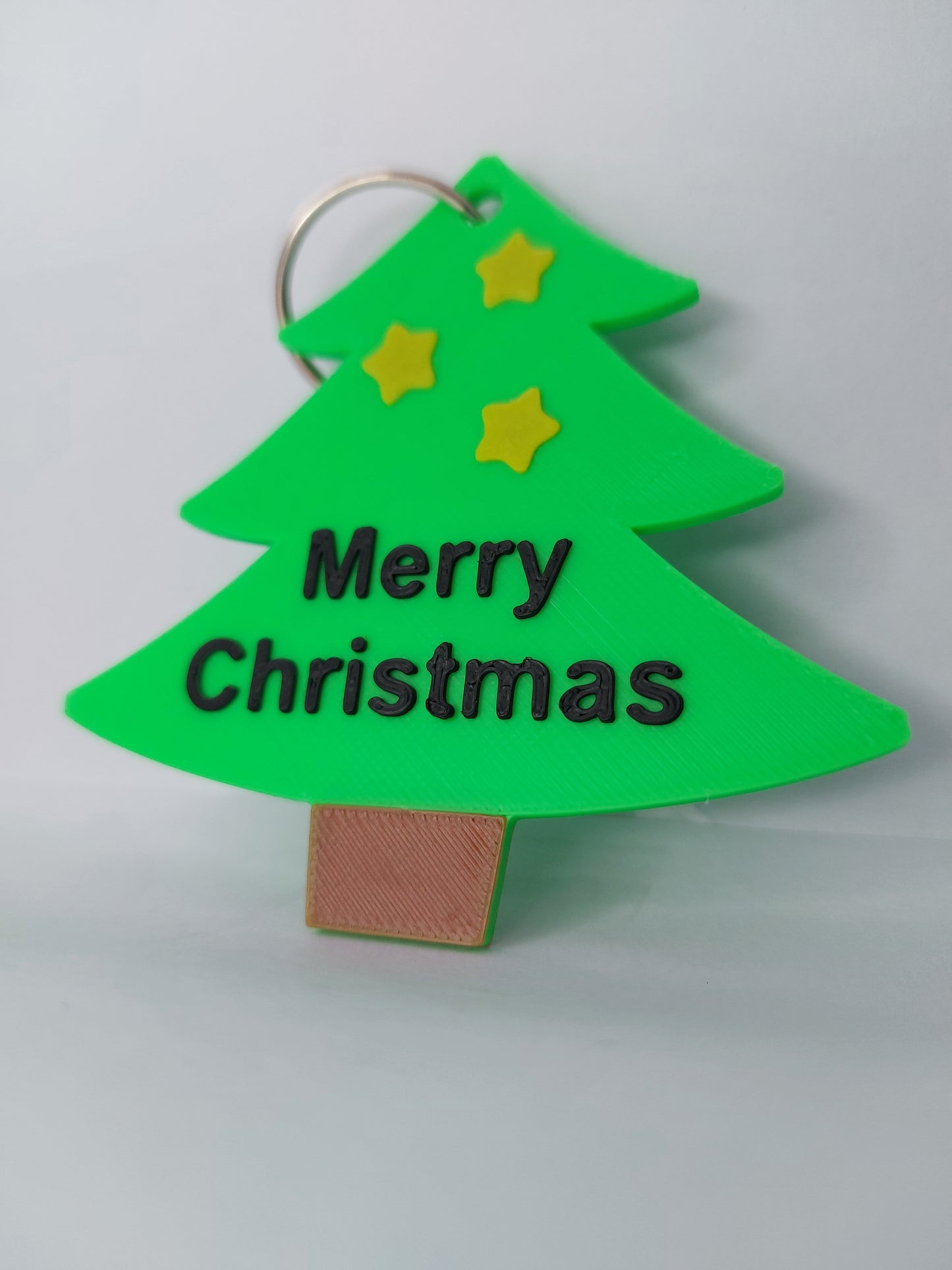 Green Christmas tree-shaped keychain with 'Merry Christmas' text on a white background