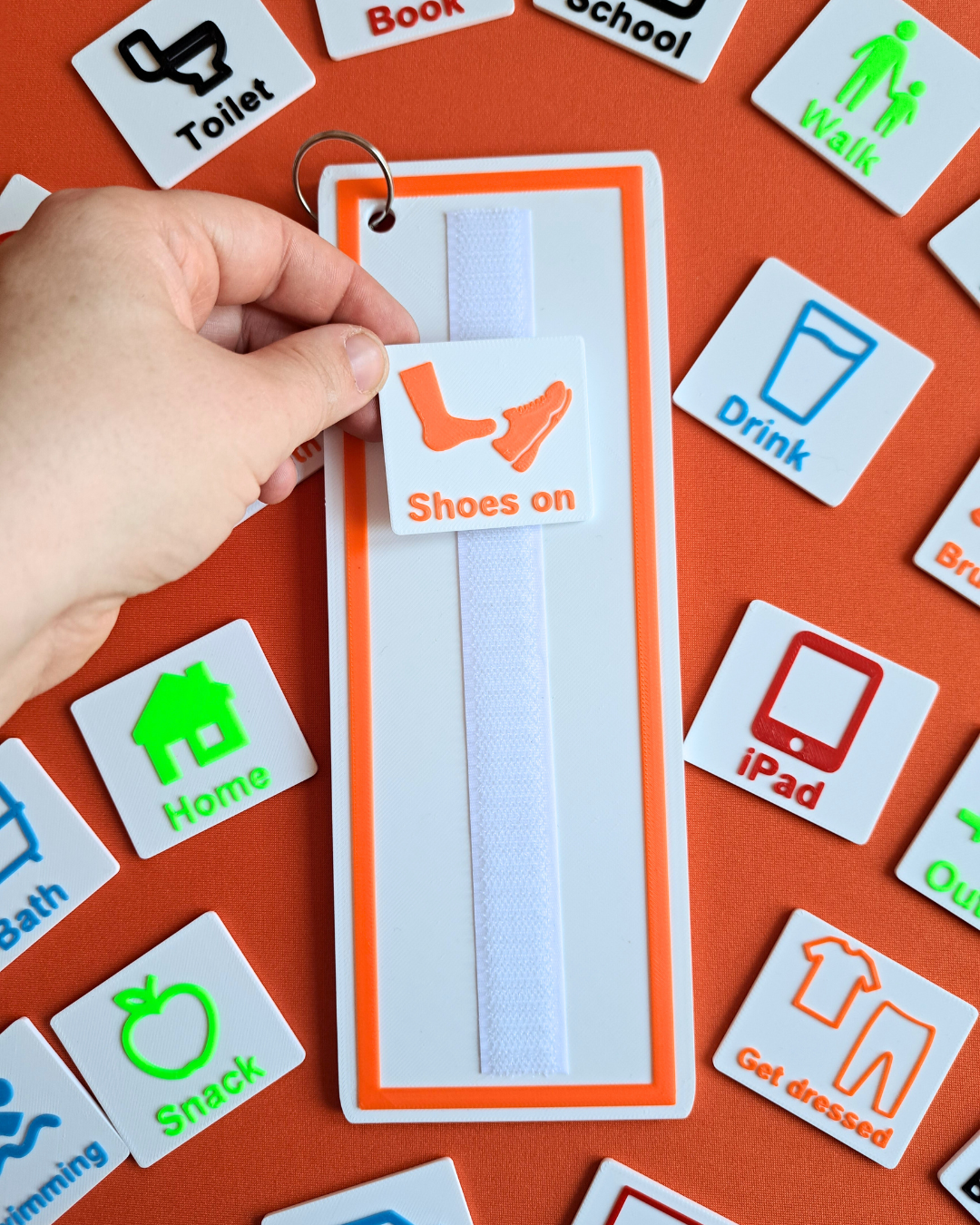 Close-up of visual schedule board and wallet with colourful daily routine tags for children.