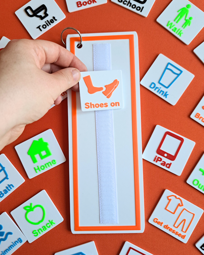 Close-up of visual schedule board and wallet with colourful daily routine tags for children.